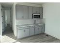 Stylish kitchenette with gray cabinets, subway tile backsplash, stainless steel sink, and modern appliances at 9354 Quartz St, Arvada, CO 80007