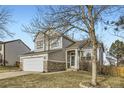 Well-maintained two-story home with a two-car garage and a mature tree in the front yard at 19827 E Prentice Ave, Centennial, CO 80015