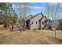 Spacious backyard featuring a wooden deck with outdoor seating, and mature trees at 31028 Big Bear Dr, Evergreen, CO 80439