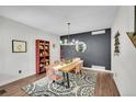 Dining room featuring wood floors, a modern light fixture, a wood table, and patterned chairs at 215 Mcafee Cir, Erie, CO 80516