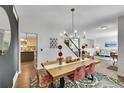 Open concept dining room featuring wood floors, and a stylish wood table with seating for six at 215 Mcafee Cir, Erie, CO 80516