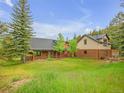 Charming log home featuring a well-manicured lawn and mature trees at 24 Pine Valley Rd, Evergreen, CO 80439