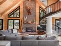 Cozy living room boasts vaulted ceilings, stone fireplace and spiral staircase at 24 Pine Valley Rd, Evergreen, CO 80439