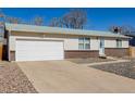 Charming home with an attached garage, large driveway, white siding, brick accents and well-maintained landscaping at 15891 E Linvale Ave, Aurora, CO 80013
