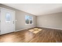 Bright living room featuring hardwood floors, large windows offering abundant natural light, and fresh paint at 15891 E Linvale Ave, Aurora, CO 80013