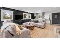 Elegant living room with a black accent wall, large windows, and stylish furniture at 8451 London Ln, Conifer, CO 80433