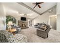 Bright living room with vaulted ceilings, a brick fireplace, and sliding glass doors to the backyard at 13036 Clayton Ct, Thornton, CO 80241