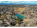 Scenic aerial shot showcasing community tennis courts, green spaces, and mountain views in a desirable neighborhood at 8109 E Phillips Cir, Centennial, CO 80112