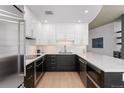 Modern kitchen with two-tone cabinets, stainless steel appliances, under-cabinet lighting, and marble countertops at 1700 Bassett St # 1014, Denver, CO 80202