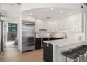 Contemporary kitchen featuring stainless steel appliances, an island, and hardwood floors at 1700 Bassett St # 1014, Denver, CO 80202