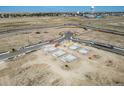 Aerial view of new construction home foundations in a developing community with roads and utilities in place at 45016 Sunflower Ln, Bennett, CO 80102