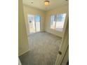 A carpeted bedroom featuring natural light from sliding glass door and a window at 45016 Sunflower Ln, Bennett, CO 80102