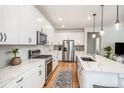Modern kitchen with white cabinets, stainless steel appliances, and a large island with a sink at 1962 Canyonpoint Ln, Castle Pines, CO 80108