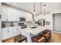 Bright, modern kitchen with white cabinets, stainless steel appliances, and a spacious island with seating at 1962 Canyonpoint Ln, Castle Pines, CO 80108