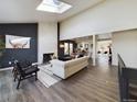 Bright living room with hardwood floors, fireplace, and skylight, creating an open space at 6378 S Emporia Cir, Englewood, CO 80111