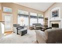 Comfortable living room with large windows, vaulted ceiling, and cozy fireplace at 13362 Marion St, Thornton, CO 80241