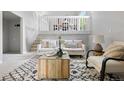 Bright living room featuring modern decor, a staircase, and a view of the dining area above at 204 Maple St, Frederick, CO 80530