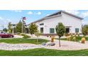 A commercial building with manicured landscaping, flag pole, and a parking area at 48230 Shetland Dr, Bennett, CO 80102