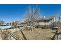 Landscaped front yard with mature trees and charming stone accents highlight this single story home at 7310 Carnation Pl, Commerce City, CO 80022
