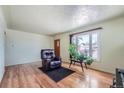 Bright living room featuring hardwood floors, fresh paint, and a large window at 6991 Warren Dr, Denver, CO 80221
