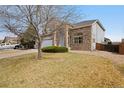 Beautiful home featuring brick accents, manicured landscaping, and a well-maintained lawn at 13078 Monaco Way, Thornton, CO 80602