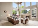 Spacious living room features a fireplace, tall windows, and a ceiling fan at 13078 Monaco Way, Thornton, CO 80602