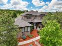 A gorgeous exterior featuring beautiful stone and manicured landscaping under a cloudy, bright sky at 4586 Carefree Trl, Parker, CO 80134
