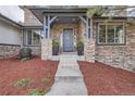 Inviting front entrance with stone accents, decorative plants, and a charming water feature at 4586 Carefree Trl, Parker, CO 80134