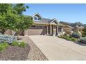 Charming home with stone accents, a spacious driveway, and mature landscaping for enhanced curb appeal at 19753 E 54Th Ave, Denver, CO 80249