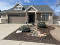 Inviting home exterior with stone accents, low-maintenance landscaping, and a spacious driveway at 19753 E 54Th Ave, Denver, CO 80249