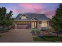 Inviting home featuring stone accents, a well-manicured lawn, and a spacious driveway for enhanced curb appeal at 19753 E 54Th Ave, Denver, CO 80249
