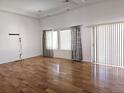 Bright living room with gleaming hardwood floors and large windows featuring decorative curtains at 19753 E 54Th Ave, Denver, CO 80249