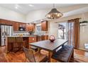 Bright dining room with a modern light fixture, wood floors, and sliding doors to the backyard at 16278 E 105Th Way, Commerce City, CO 80022