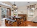 Bright dining room with a modern light fixture, wood floors, and sliding doors to the backyard at 16278 E 105Th Way, Commerce City, CO 80022