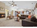 Inviting living room with a cozy fireplace, plush carpeting and an open floor plan at 16278 E 105Th Way, Commerce City, CO 80022