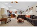 Open-concept living room with a large sectional sofa and view of the kitchen, perfect for entertaining at 16278 E 105Th Way, Commerce City, CO 80022