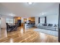 Open-concept living space featuring hardwood floors connecting the kitchen, dining, and living areas at 3150 W Stanford Ave, Englewood, CO 80110