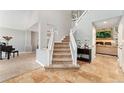Grand entryway with high ceilings, tiled floors, and an open staircase with white railing at 1774 Brookside Dr, Highlands Ranch, CO 80126