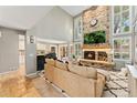 Inviting living room features a stone fireplace, soaring ceilings, and large windows at 1774 Brookside Dr, Highlands Ranch, CO 80126