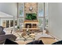 Comfortable living room has a stone fireplace, bright windows, and modern decor at 1774 Brookside Dr, Highlands Ranch, CO 80126