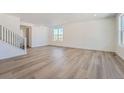 Spacious and well-lit living room showcasing modern wood-style flooring and white walls at 738 N Clubview St, Watkins, CO 80137