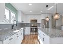 Bright kitchen with stainless steel appliances, granite countertops, an island, and sleek white cabinetry at 11886 W 107Th Ave, Westminster, CO 80021