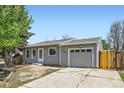 Charming one-story home featuring a garage, light gray siding, and a paved driveway at 1958 Cathay Ct, Aurora, CO 80011