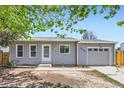 Charming one-story home featuring a garage, light gray siding and a well-manicured lawn at 1958 Cathay Ct, Aurora, CO 80011