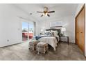 Cozy bedroom with a ceiling fan, large bed, neutral colors, and access to a private balcony at 8424 Everett Way # E, Arvada, CO 80005