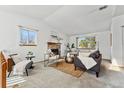 Bright living room with a stone fireplace, neutral decor, and lots of natural light at 8424 Everett Way # E, Arvada, CO 80005
