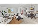 Open-concept living room with modern decor, dining area, and easy access to the kitchen at 8424 Everett Way # E, Arvada, CO 80005