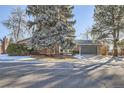 Brick ranch home with gray garage door and mature landscaping at 7076 S Newland St, Littleton, CO 80128