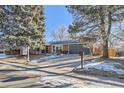 Updated brick ranch home with a dark gray garage door at 7076 S Newland St, Littleton, CO 80128