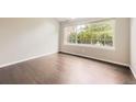 A spacious bedroom with gleaming hardwood floors, a large window, and freshly painted walls at 2247 S Lima Ct, Aurora, CO 80014